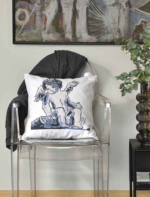 benjamin White cotton square cushion made of 100% cotton, with blue angel figure print that decorates a living room, on a design see through plastic chair.