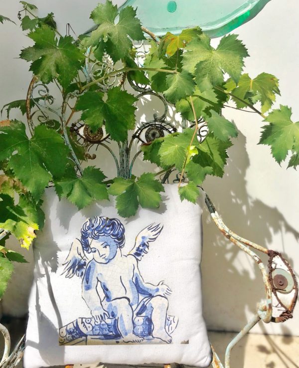 benjamin White cushion made of 100% cotton, with angel print, blue, decorates the outside of the house, on a blue metal armchair.