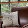 dear deer beige cushion made of 100% cotton, with a wonderful print winged deer design with a crown, decorates a fabric armchair in a modern house.