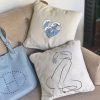 fabula beige cushion made of 100% cotton, with printed female body design, decorates beige sofa.