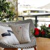 fingertips beige cushion made of 100% cotton, with art deco pattern painted fingers on an armchair on a home terrace.