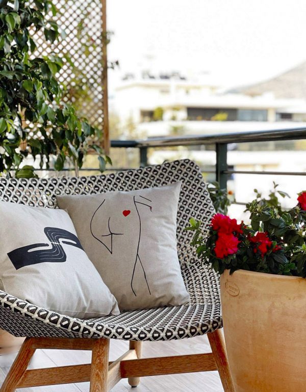 fingertips beige cushion made of 100% cotton, with art deco pattern painted fingers on an armchair on a home terrace.