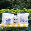 juliete White cushion made of 100% cotton, with a print of a blue vase with flowers decorates the outside of the house, on a metal garden armchair.