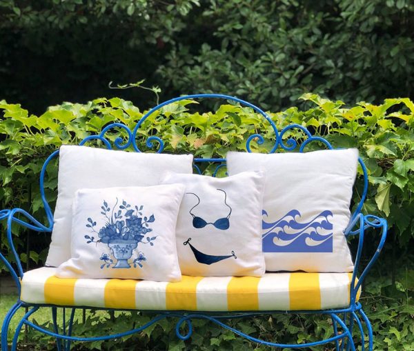 juliete White cushion made of 100% cotton, with a print of a blue vase with flowers decorates the outside of the house, on a metal garden armchair.