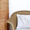 nipple beige cushion made of 100% cotton, print contour female body and chest on a bamboo chair.