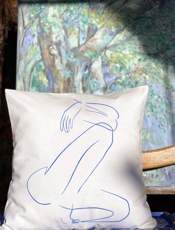 blue fabula white cushion made of 100% cotton, with print female body design, in front of autumn table with nature.