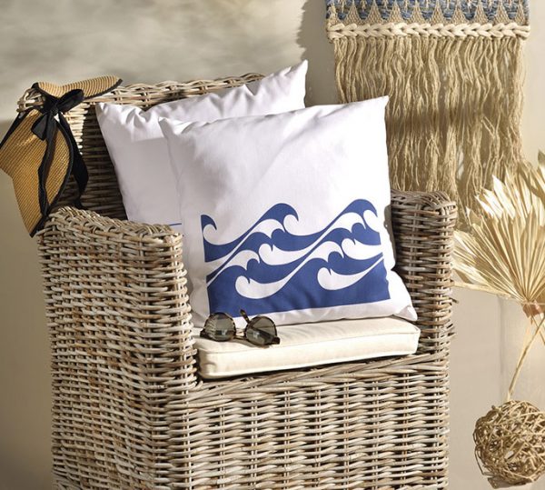 nautico Λινό λευκό μαξιλάρι κήπου 46x46 με μπλε κύματα πάνω σε μπαμπού πολυθρόνα σε καλοκαιρινό σπίτι