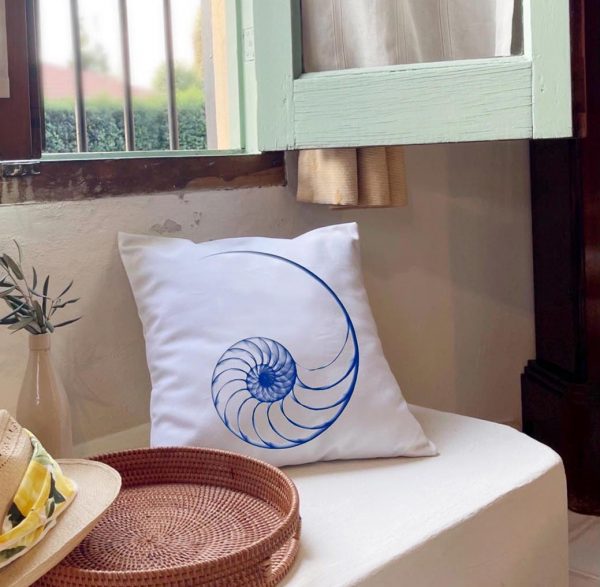 nautilus II Linen white cushion 46x46 with blue shell outline design on a home interior bench.
