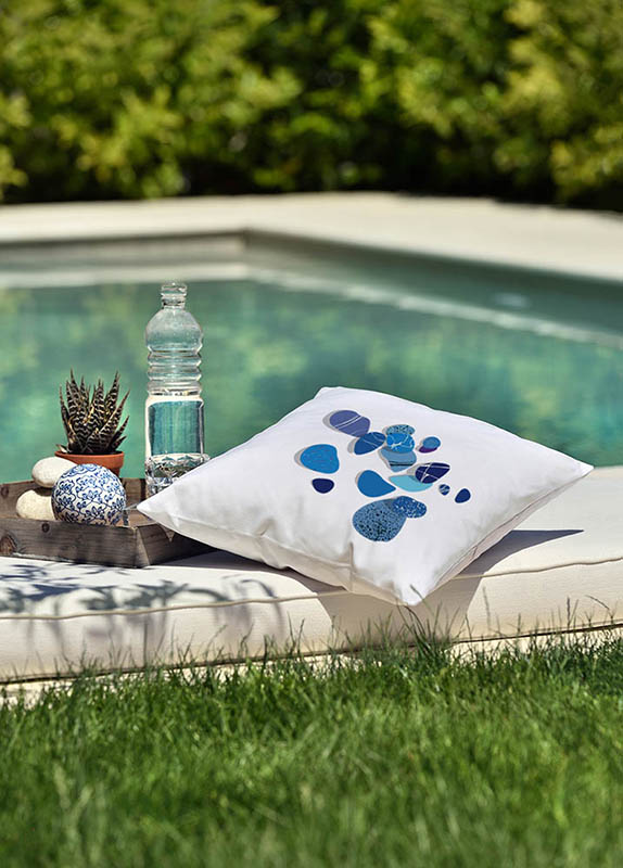 Small pebbles blue Λευκό μαξιλάρι από 100% βαμβάκι, με τύπωμα μπλε μικρά βότσαλα σε κήπο μπροστά από πισίνα.